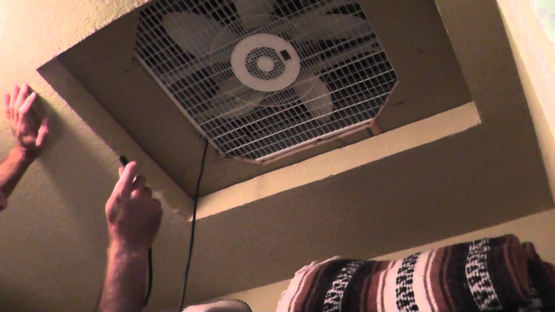 A person is holding the fan up to cool it.